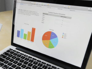 stock image of a laptop open with survey results in graphs