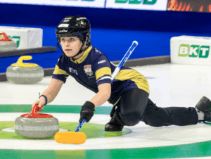 Youth athlete sliding out of hack releasing a curling rock