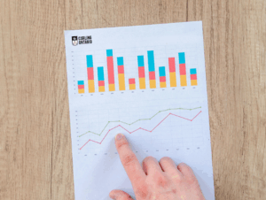 Image of a hand pointing to a piece of paper with a graph on it