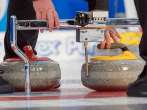 image of an umpire measuring a red and yellow rock in a competition