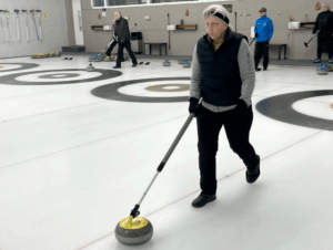 Image of a woman playing stick curling