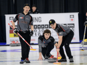 Team Ontario men's team throwing a rock and sweeping