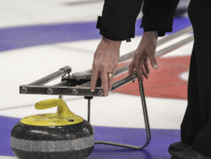 umpire measuring a yellow rock