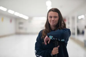 U15 Triples Cup player leaning on her broom smiling