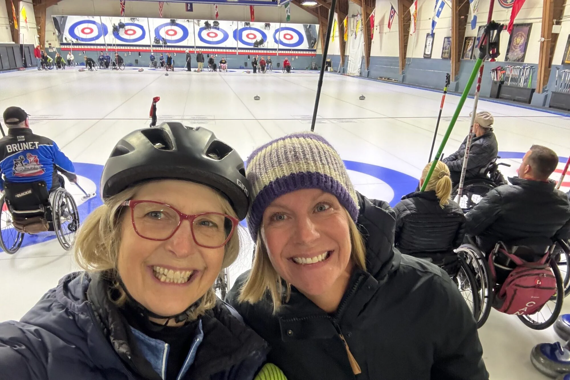 two female curlers out on the ice wheelchair curling