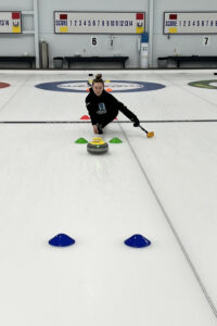 female curler sliding through pylons