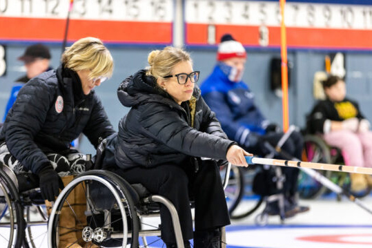 Wheelchair curler throwing a rock