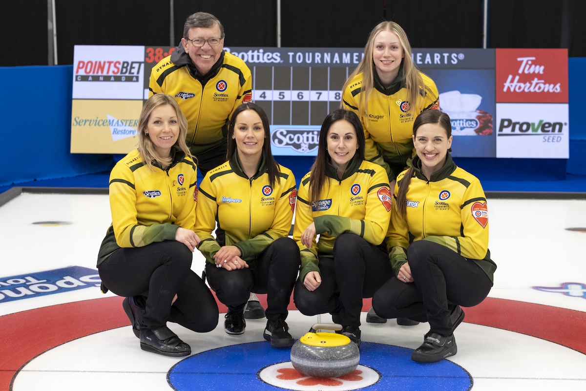 Team Northern Ontario at the Scotties Tournament of hearts posing for a photo as a team with the coaches.